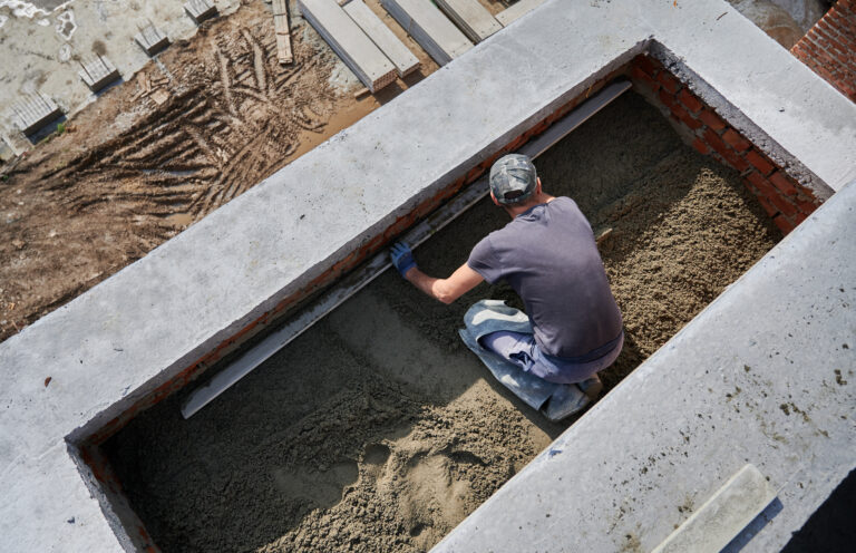 male worker screeding floor at construction site.
